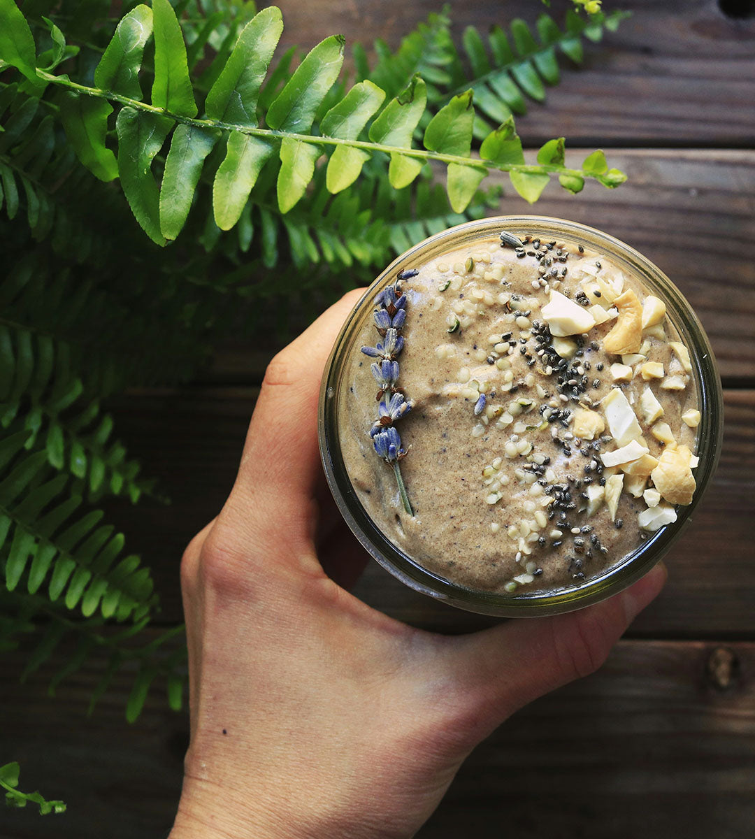 A healthy smoothie topped with organic mānuka honey, chia seeds, and coconut flakes.