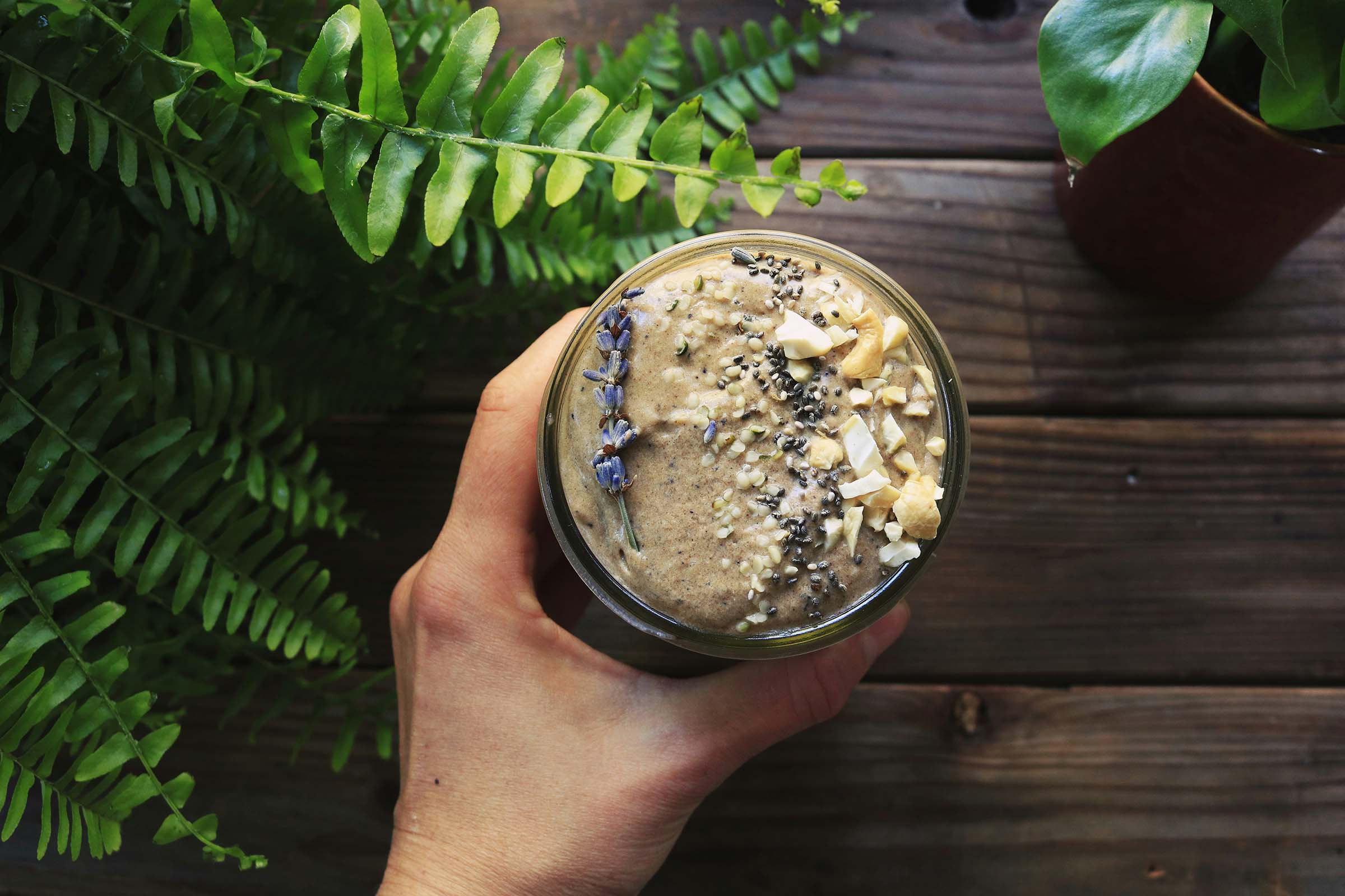 A healthy smoothie topped with organic mānuka honey, chia seeds, and coconut flakes.